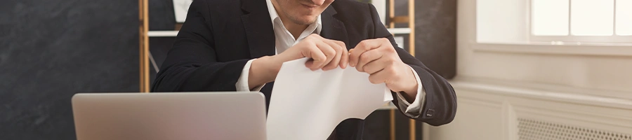 A business person about to rip a paper in half