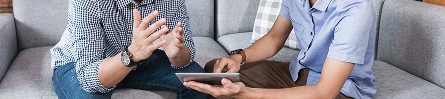 Two people sitting and talking about the selection process of LLC service in Arkansas