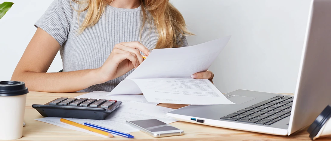 Venture Smarter | How to File LLC Taxes in Michigan? (A Complete Guide) Businesswoman busy working on Michigan LLC taxes documents